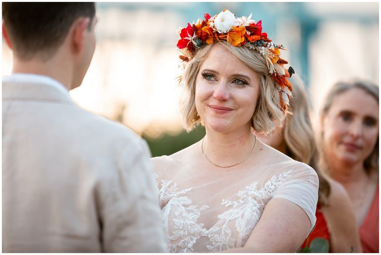 Bride with fall flower crown staring at groom during wedding ceremony